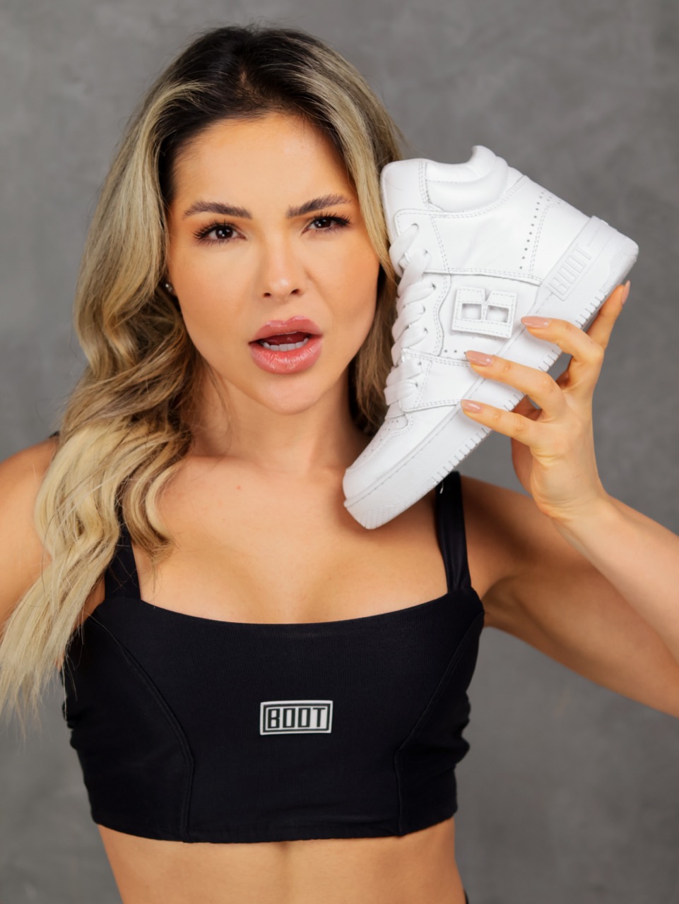 Modelo sosteniendo una zapatilla Boot Training blanca
